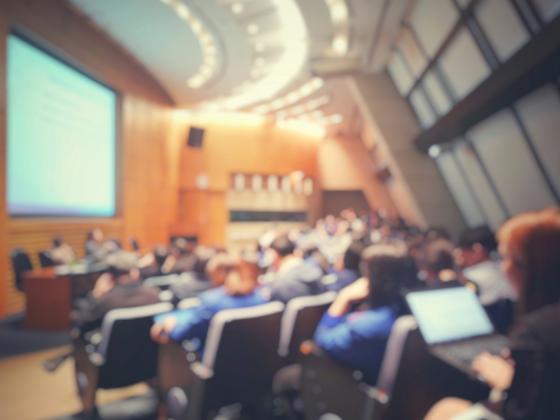 Uskarpt bilde av et panel og tilhørere i et auditorium