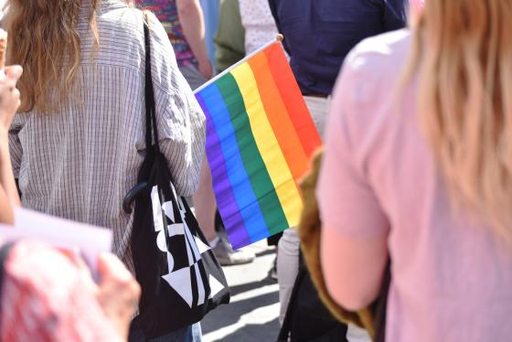 Gruppe med mennesker som markerer Pride med regnbueflagg