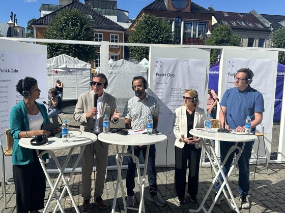 Ordstyrer og fire paneldeltakere på scenen ute på Arendal torv